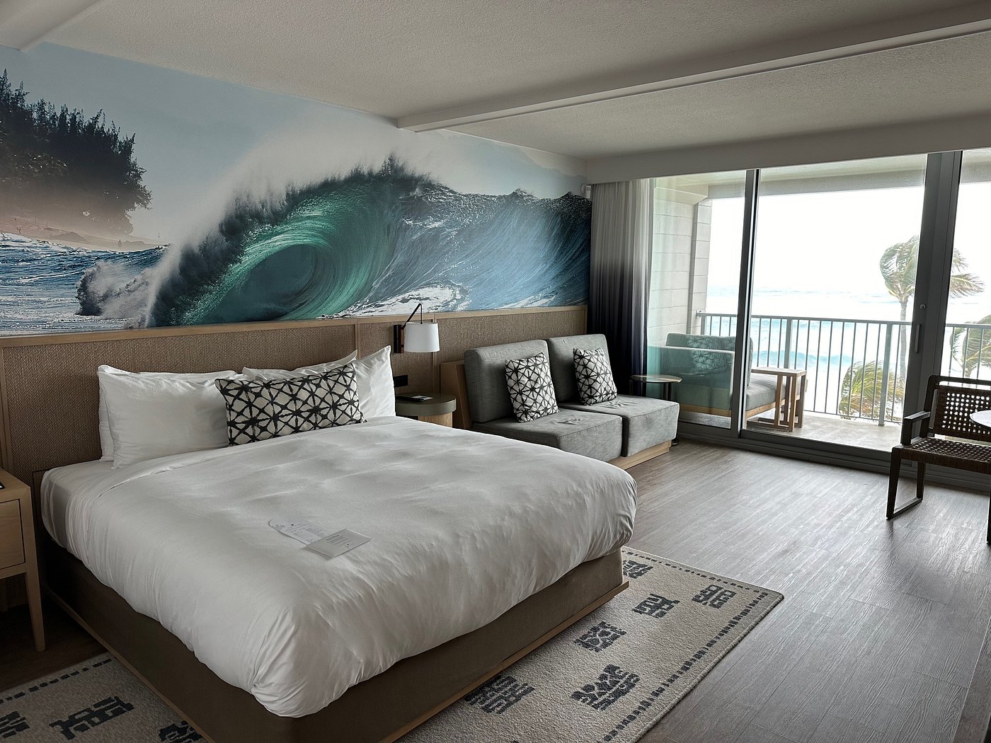 Guest room with wave artwork and ocean-facing lanai at Turtle Bay